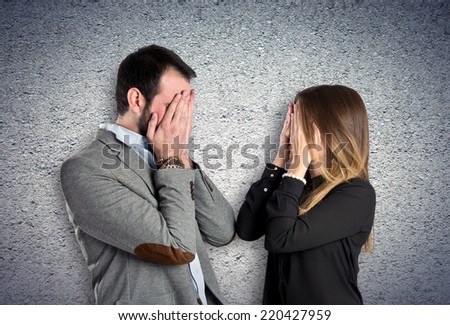 Couple covering their eyes over textured background