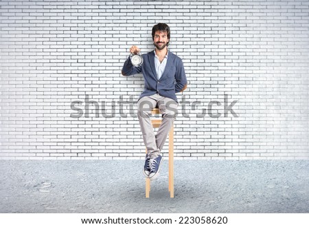 Man holding a clock over textured background