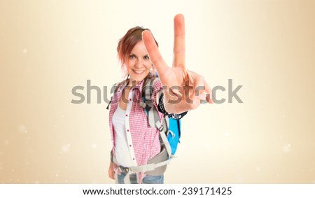 backpacker doing victory gesture over white background