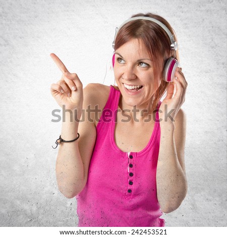 Young girl listening music over textured background