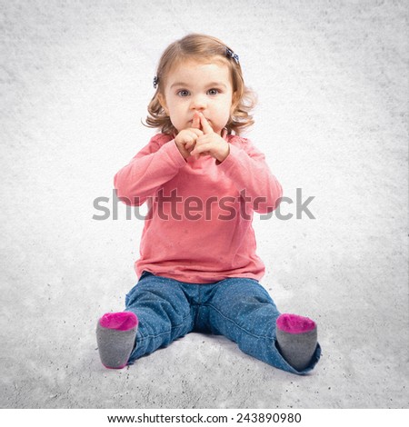Cute girl doing silence gesture over textured background