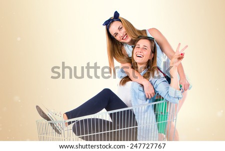 Girls playing with supermarket cart