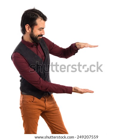 Man wearing waistcoat holding something