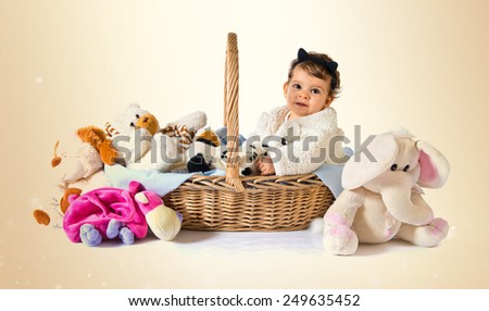 Cute baby inside basket with stuffed animals