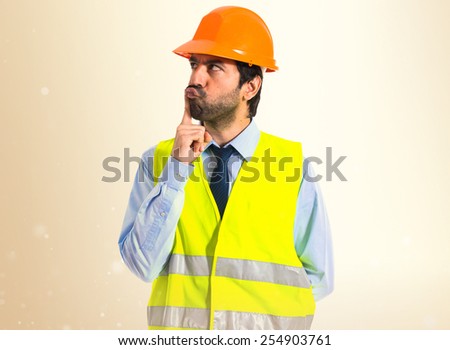 worker thinking over ocher background
