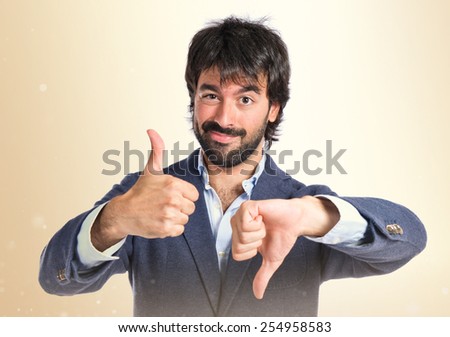 Handsome man making a good-bad sign over white background