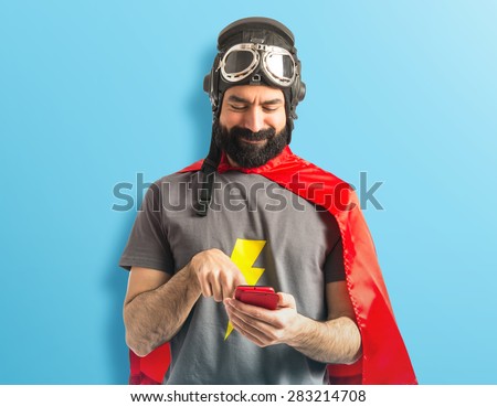 Superhero writting a sms over colorful background