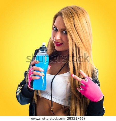 Sport woman holding energy drink and doing victory gesture