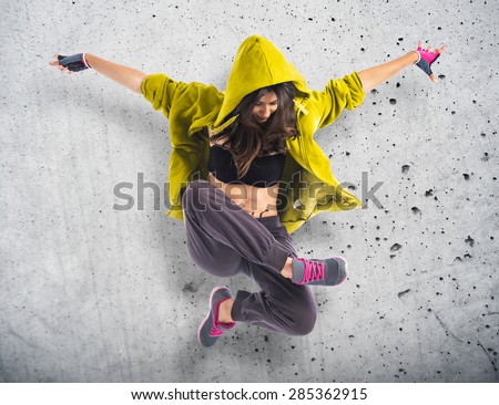 Teenager girl dancing hip hop over textured background