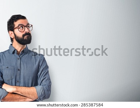 Young hipster man thinking over textured background