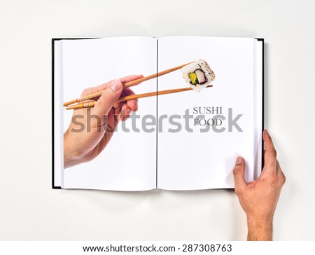 hand holding sushi with chopsticks printed on book