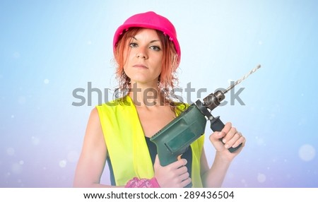 Worker woman with drill over shiny background