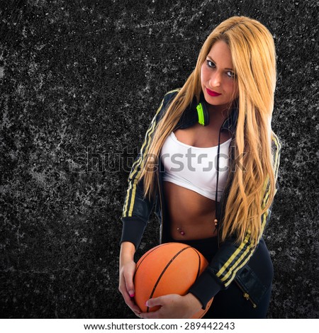 Sexy girl with a basketball over textured background