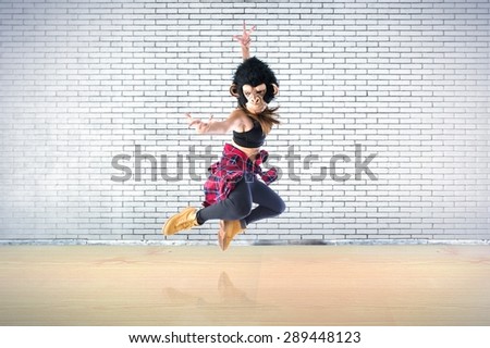 Woman with monkey mask jumping in hip hop style