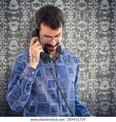 Vintage young man talking to vintage phone over vintage background