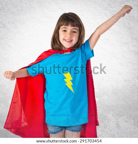 Girl dressed like superhero over grey background