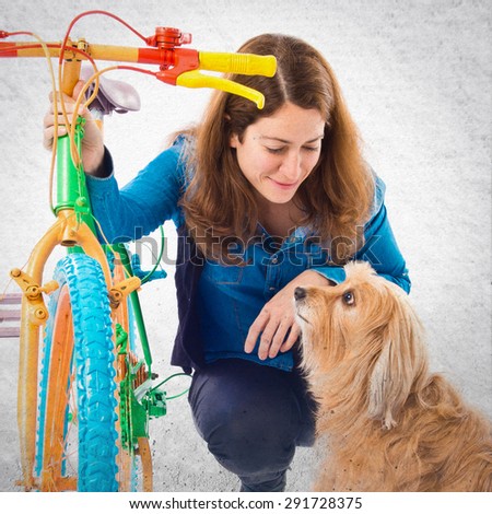Woman and dog with colorful bike over grey background