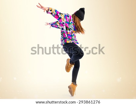 Young woman dancing street dance over ocher background Foto stock © 