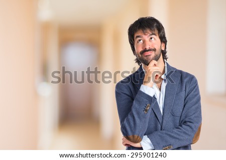 Businessman thinking inside house on unfocused background