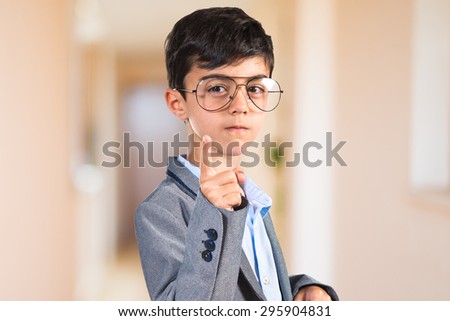 Child with vintage glasses pointing to the front inside house