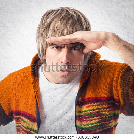 Blonde man showing something over grey background