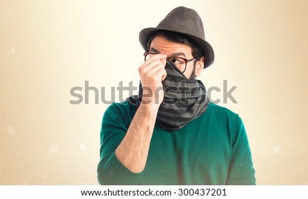 Man covering his face over ocher background