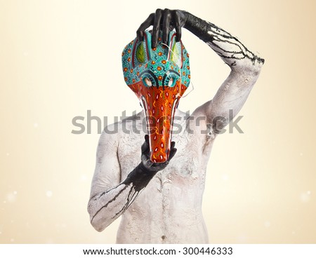 primitive man with fox mask over ocher background