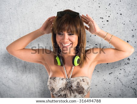 Woman in bikini listening music over textured background