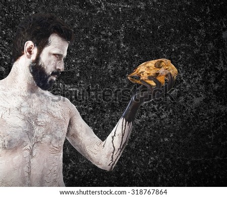 primitive man looking a rabbit skull