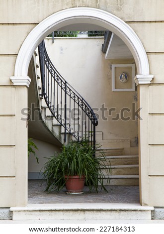 arched entrance with potted plant in the background and scale