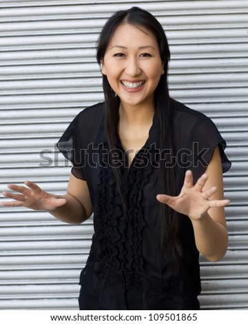 Attractive Asian woman outdoors wearing short sleeved black shirt and black pants