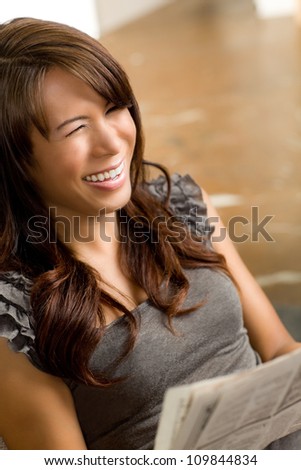 Beautiful Hispanic woman relaxing at home wearing short sleeve gray shirt and shorts.