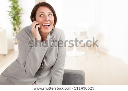 Attractive Caucasian female at work wearing a grey suit with short brown hair.