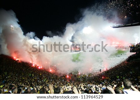THESSALONIKI, GREECE - AUGUST 5: Fans and supporters of ARIS team light flares in football match between Aris and Boca Juniors cheering for their team goals on August 5, 2009 in Thessaloniki, Greece.