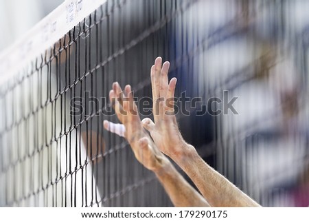 THESSALONIKI, GREECE  - FEBRUARY 15, 2014 :  Hands on net during the Hellenic Volleyball League game Paok vs Olympiacos at PAOK Sports Arena. Shallow dof.