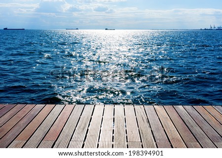 Wooden platform beside the ocean and blue sky
