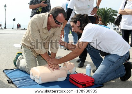 THESSALONIKI, GREECE- OCTUBER 16, 2013: People practicing CPR on a mannequin, with the instructor\'s help. Free First Aid, CPR lessons given in the center of Thessaloniki, Greece.