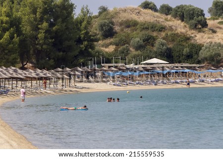 MARMARAS, GREECE- JULY 29, 2014: Tourists enjoying a nice summer day at the hotel Porto Carras beach of Marmaras in Chalkidiki, Greece. Porto Carras is the most outstanding family resort in Greece.