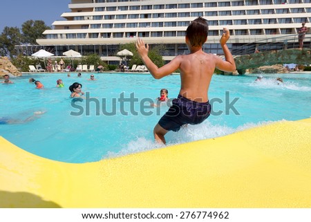 PORTO KARRAS, CHALKIDIKI- JULY 29, 2014: Visitors jumping in to the pool, having fun on a hot day in summer in Chalkidiki, Greece.