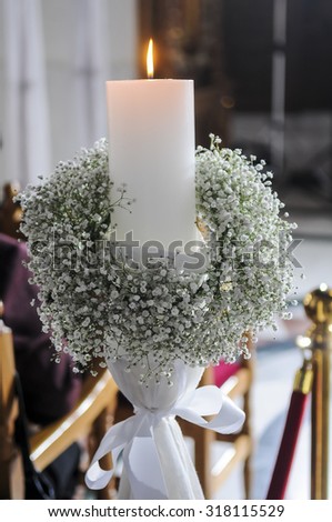 White candles and carnations flower wedding decoration in a church