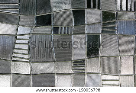 stained glass window with irregular block pattern in a hue of gray, square format
