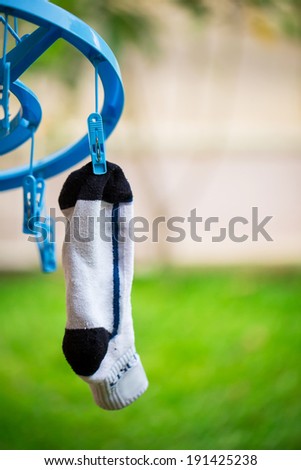 white sock on washing line with wooden clothes peg and bubbles