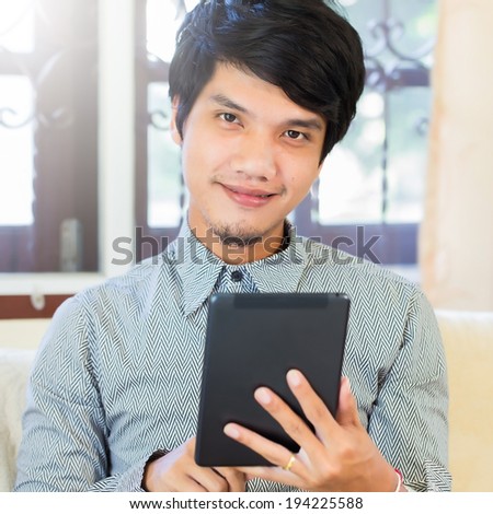 Serious young male executive using digital tablet
