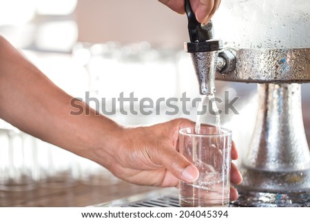 Human hand holding glass pouring fresh drink water