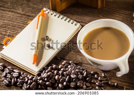 Still life of Pencil on a white spiral squared notebook with cup of coffee
