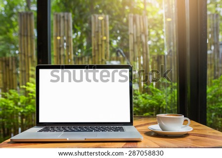 laptop for blank and coffee on a table showing break or breakfast in coffee shop or office,late art