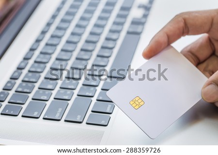 technology, shopping, banking, home and lifestyle concept - close up credit card with laptop computer