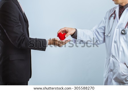 doctor with stethoscope holding symbol of heart and gave heart to businessmen,Healthcare and medical concept