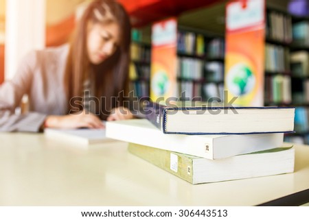 Book on table on blur background of Student with open book reading it,In college library