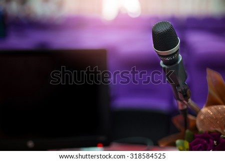 Microphone in concert hall or conference room with defocused bokeh lights in background. Extremely shallow dof